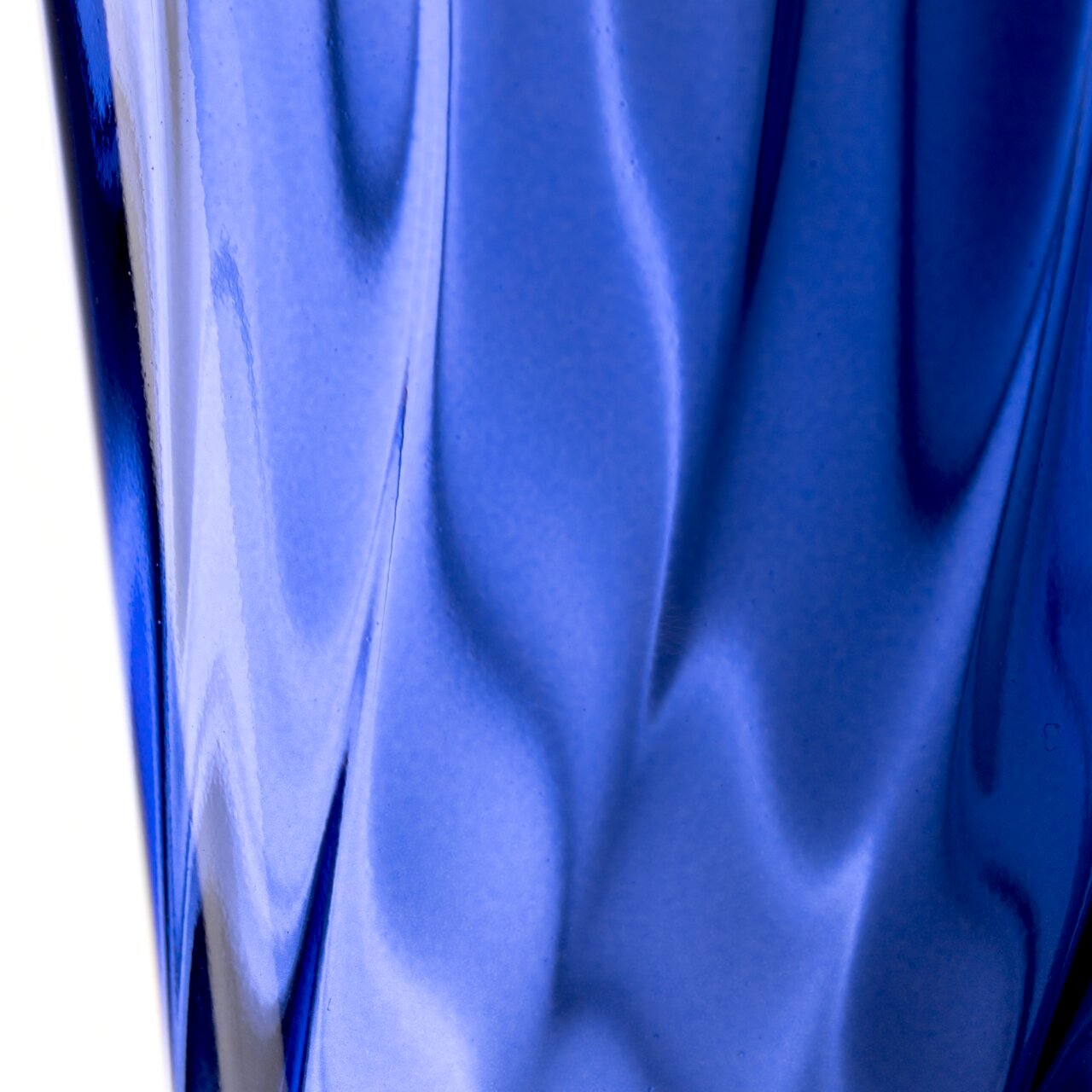 Nahaufnahme eines blauen Trinkglases mit gedrehtem Design, seitliche Perspektive