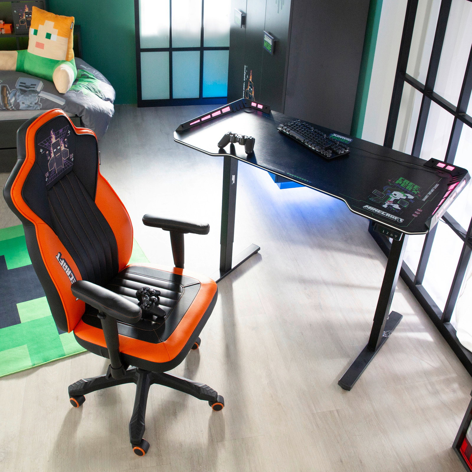 Gaming-Tisch mit LED-Beleuchtung und ergonomischem Design, abgebildet aus einer schrägen Vogelperspektive, neben einem orange-schwarzen Gaming-Stuhl.
