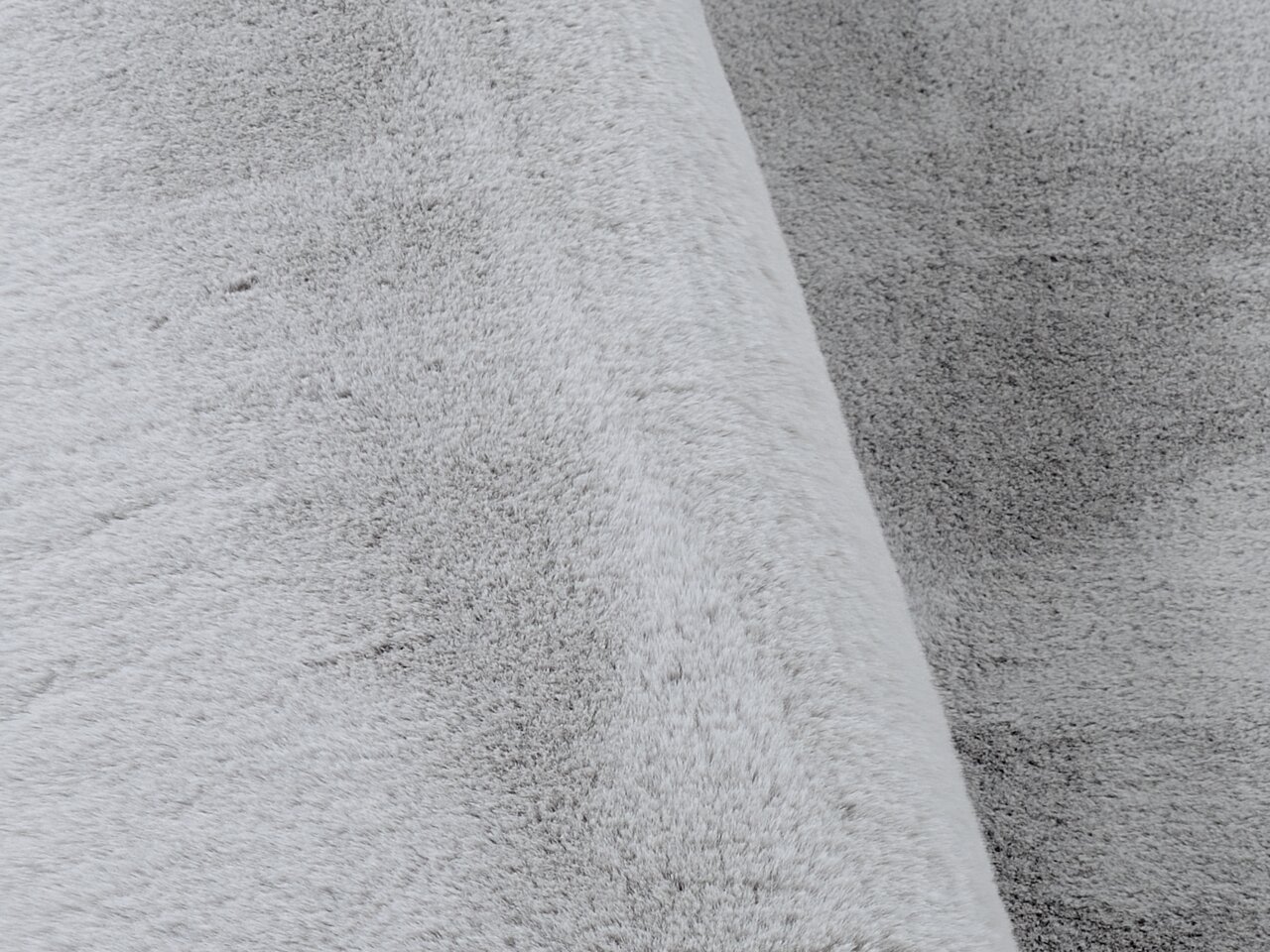 Nahaufnahme eines grauen Fellteppichs mit weicher Textur