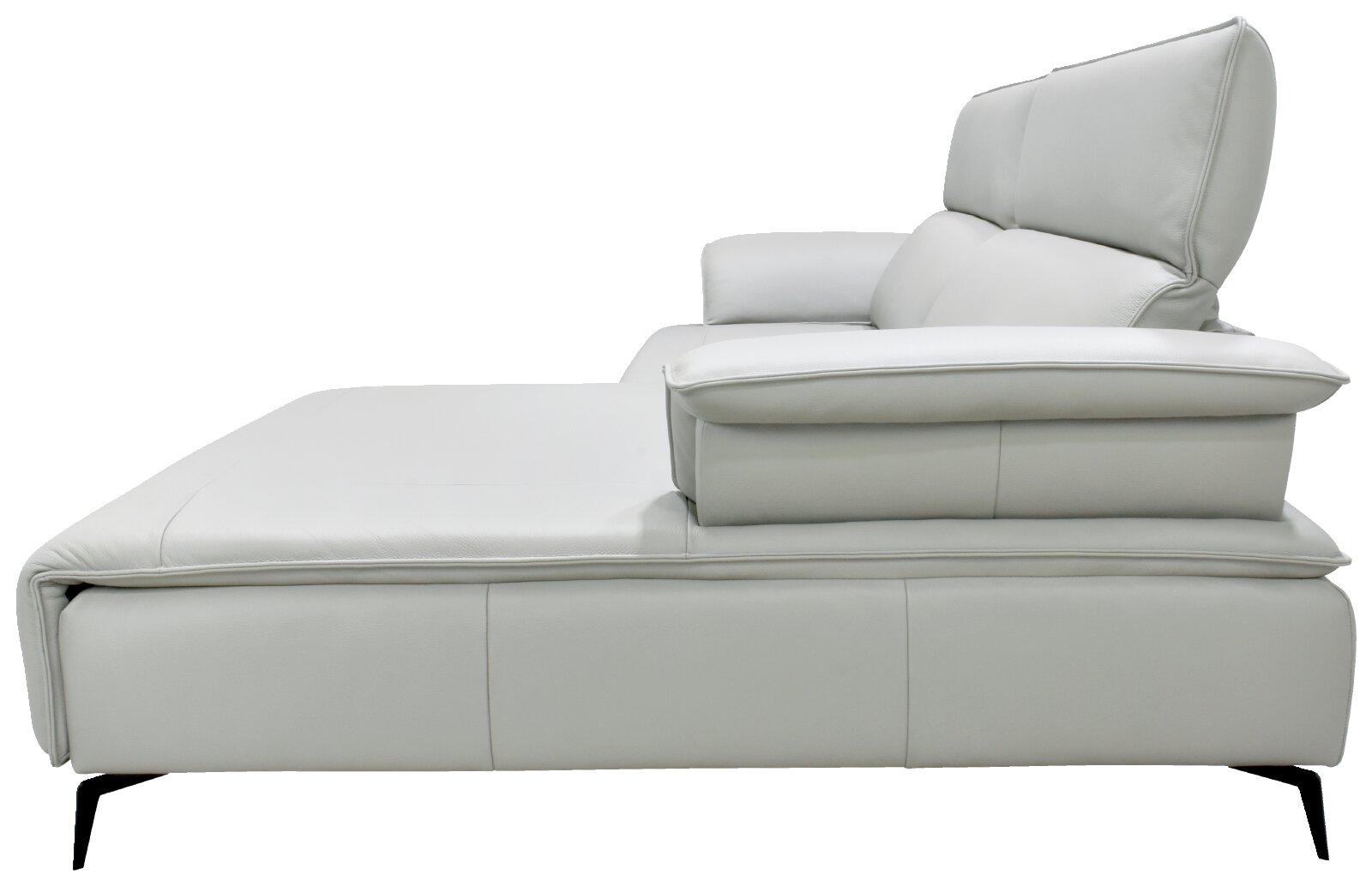 Zijaanzicht van een moderne witte leren chaise longue met verstelbare hoofdsteun, royale kussens en slanke zwarte poten