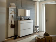 Moderner Eingangsbereich mit Garderobenset, bestehend aus einem weißen Schrank mit drei Schubladen und einer Wandgarderobe mit Haken und Ablage, seitliche Perspektive.