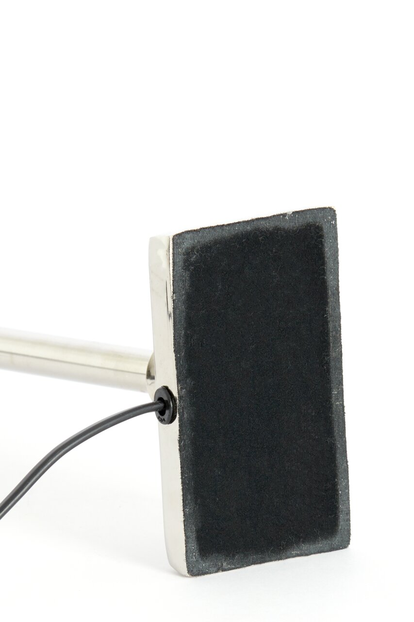 Nahaufnahme des Lampenfußes KOTA in Nickel mit rechteckiger Basis und Kabelanschluss.