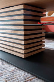 Detailansicht eines Couchtischs mit gestapelten Holz- und Metallelementen in moderner Optik.