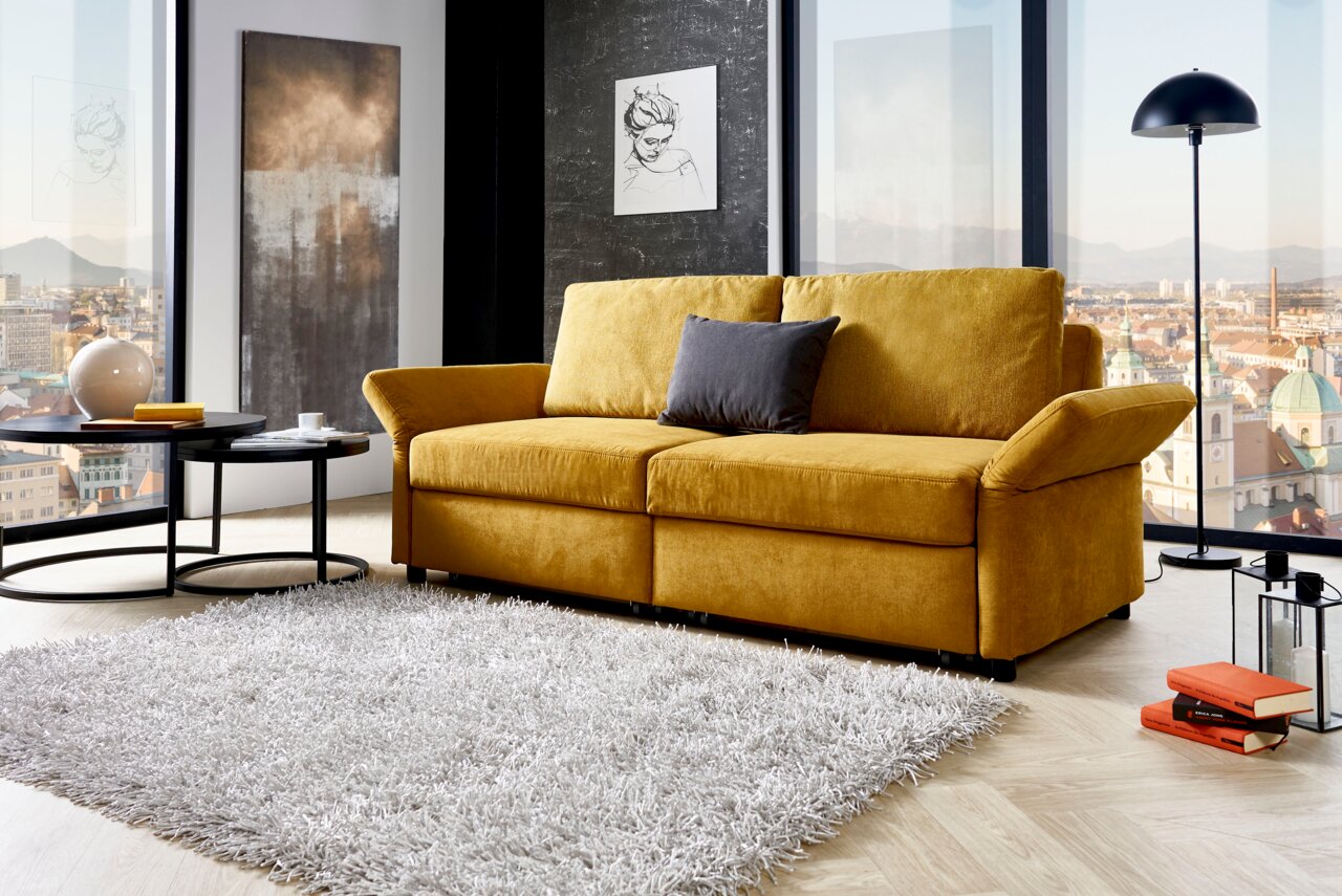 Gelbes Funktionssofa in modernem Wohnzimmer mit Stadtblick, seitliche Perspektive