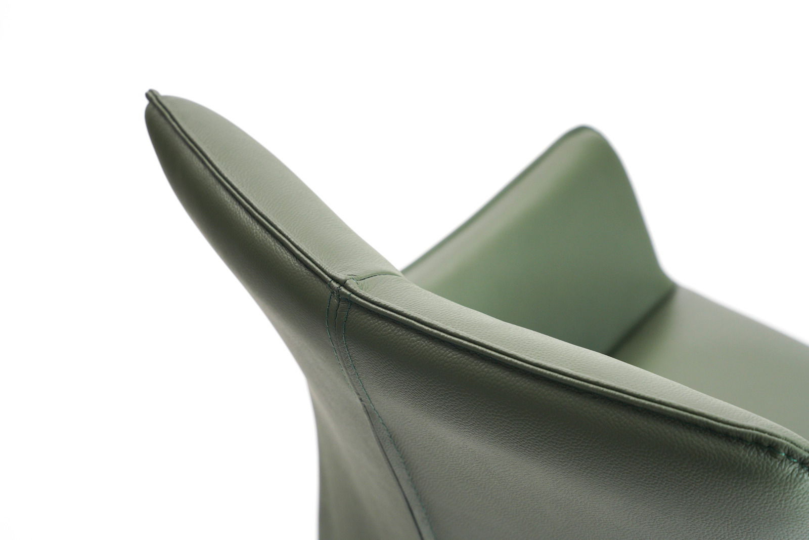 Nahaufnahme eines grünen Armlehnstuhls aus Leder, seitliche Perspektive