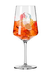 Ein Weinglas mit einem bunten tropischen Design, gefüllt mit einem orangefarbenen Getränk und Eiswürfeln, aus der Seitenperspektive.