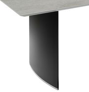 Detailansicht eines Esstisches mit schwarzem, gebogenem Tischbein und heller Tischplatte.