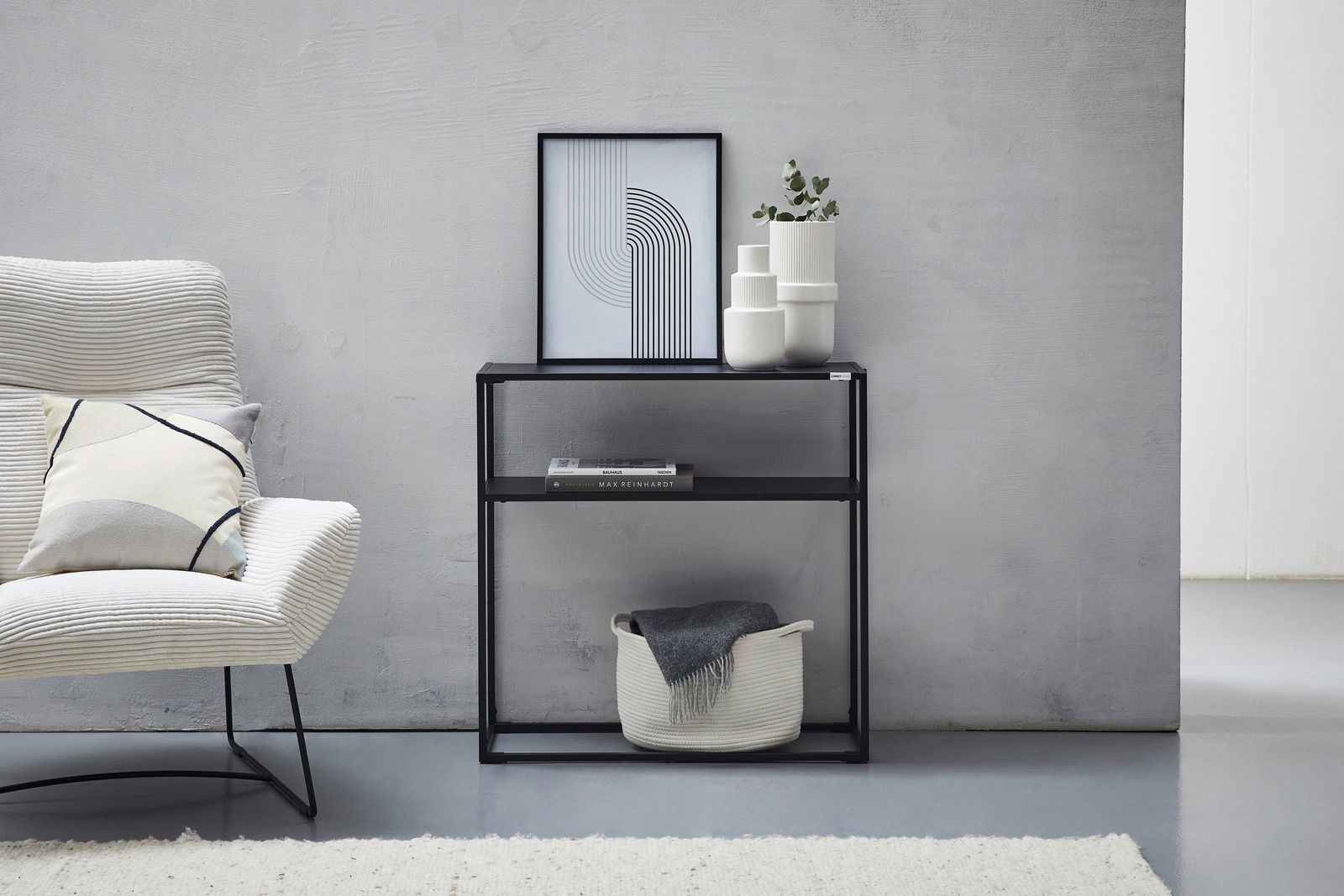 Moderne schwarze Konsole mit zwei Regalböden, dekoriert mit einem gerahmten Bild, weißen Vasen und einem Korb, seitliche Perspektive.