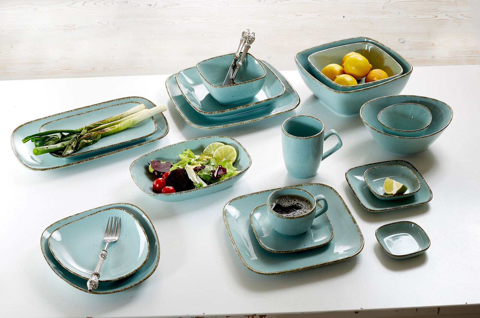 Ritzenhoff & Breker Untertasse CASA eckig blau Verschiedene blaue Geschirrteile aus der Vogelperspektive, darunter Teller, Schalen und Tassen, teilweise mit Lebensmitteln dekoriert.