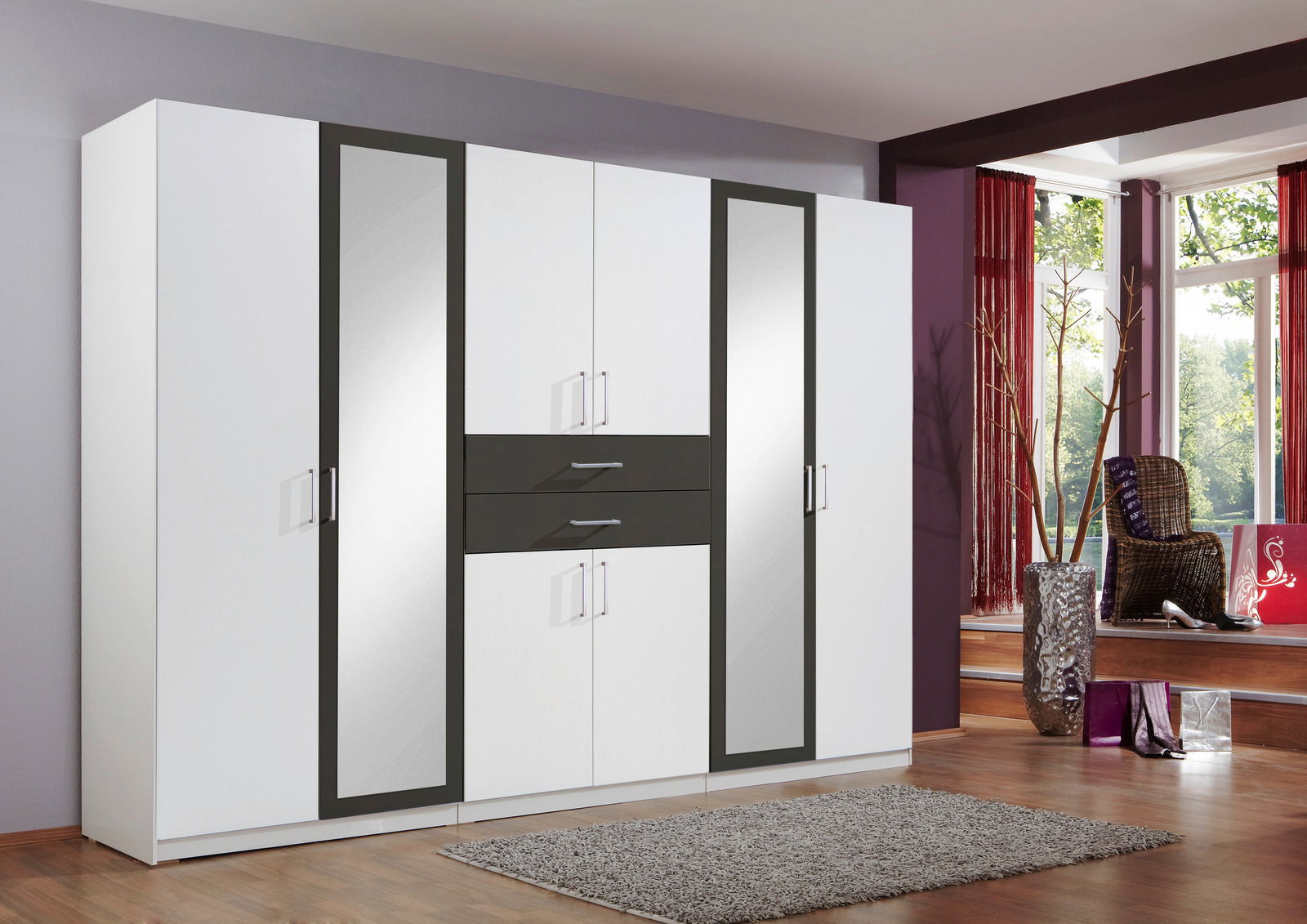 Moderner 8-türiger Drehtürenschrank in Weiß mit dunklen Akzenten und Spiegeln, frontal abgebildet in einem stilvollen Raum.