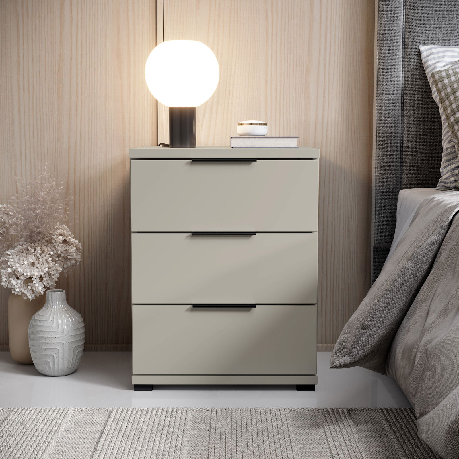 Moderne Nachtkommode mit drei Schubladen, dekoriert mit einer Lampe und Vasen, seitliche Perspektive