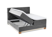 Boxspringbett mit hochgeklappter Matratze und Stauraum, seitliche Perspektive