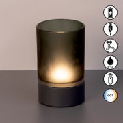 Akku-Windlicht mit zylindrischem, mattem Glas und dunklem Sockel, frontal fotografiert. Symbole für USB-Ladung, Touch-Bedienung, IP54-Schutz, Fernbedienung und CCT-Farbtemperaturregelung sind sichtbar.
