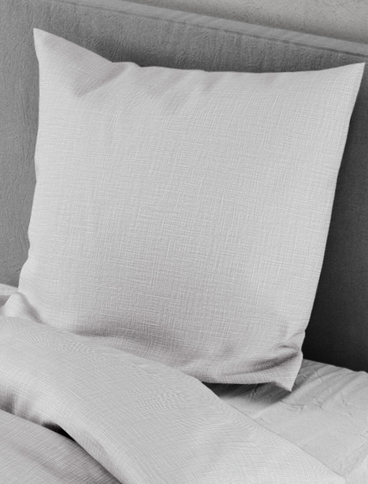 Bettwäsche-Set in hellem Grau mit feiner Struktur, bestehend aus einem Kissenbezug und einem Bettdeckenbezug, auf einem Bett arrangiert, seitliche Perspektive.