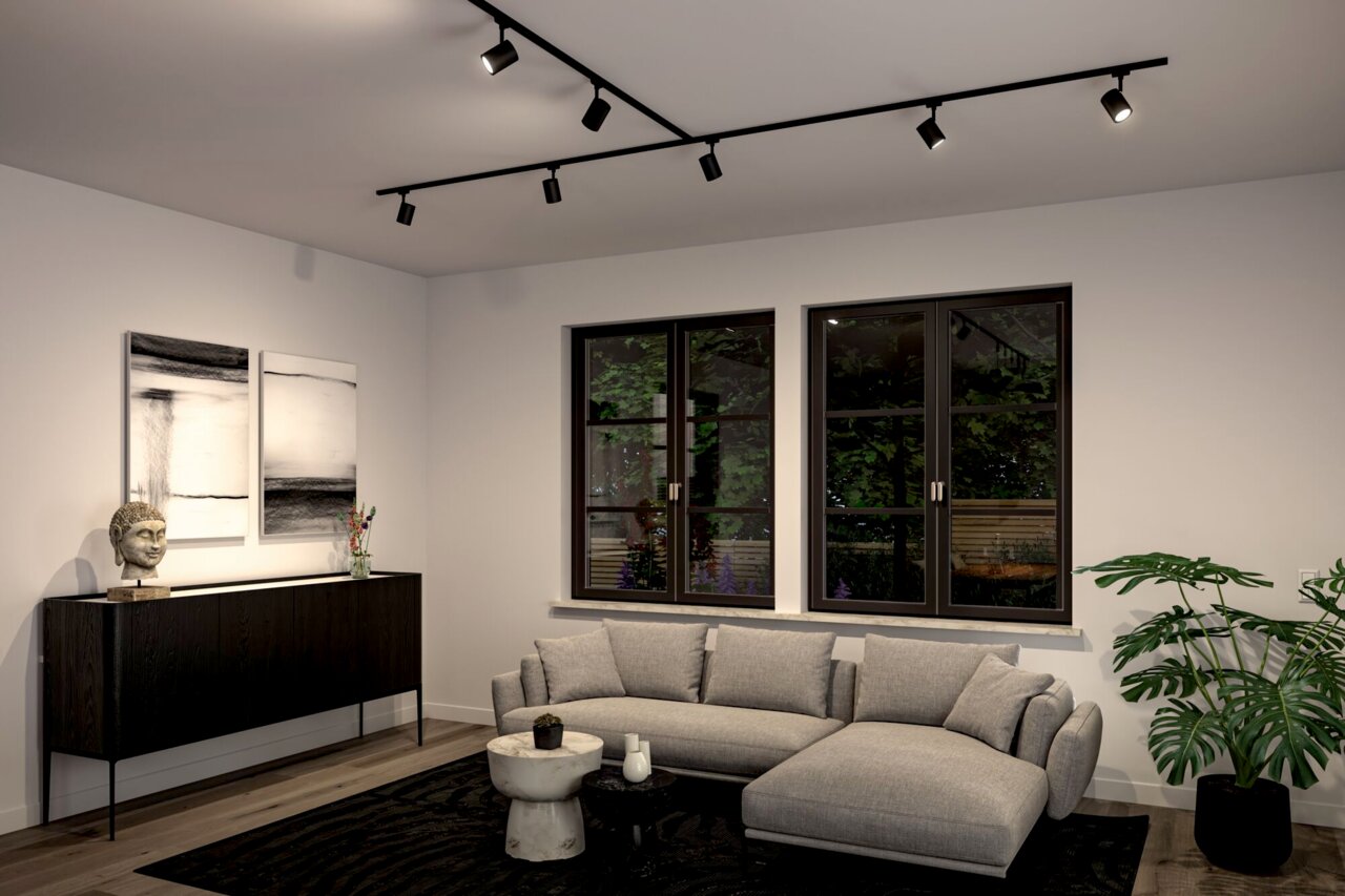 Moderne Wohnzimmeransicht mit Schienenspot Luxe Beleuchtung an der Decke, grauem Sofa, schwarzem Sideboard und großen Fenstern mit Blick auf den Garten.