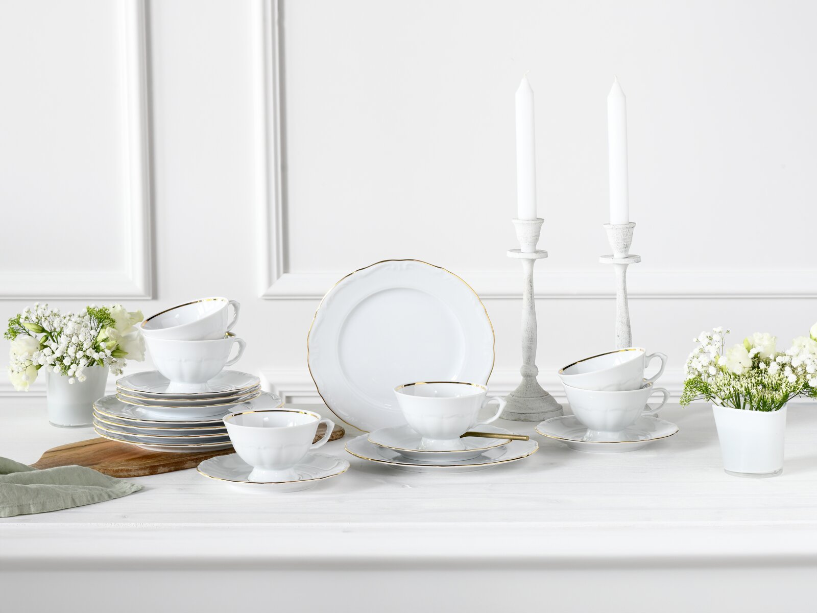 Creatable Kaffeeservice 18-tlg MARIA THERESIA Weißes Porzellan-Kaffeeservice mit Goldrand, Tassen und Tellern dekorativ auf einem Tisch arrangiert, frontal in leicht erhöhter Perspektive fotografiert.