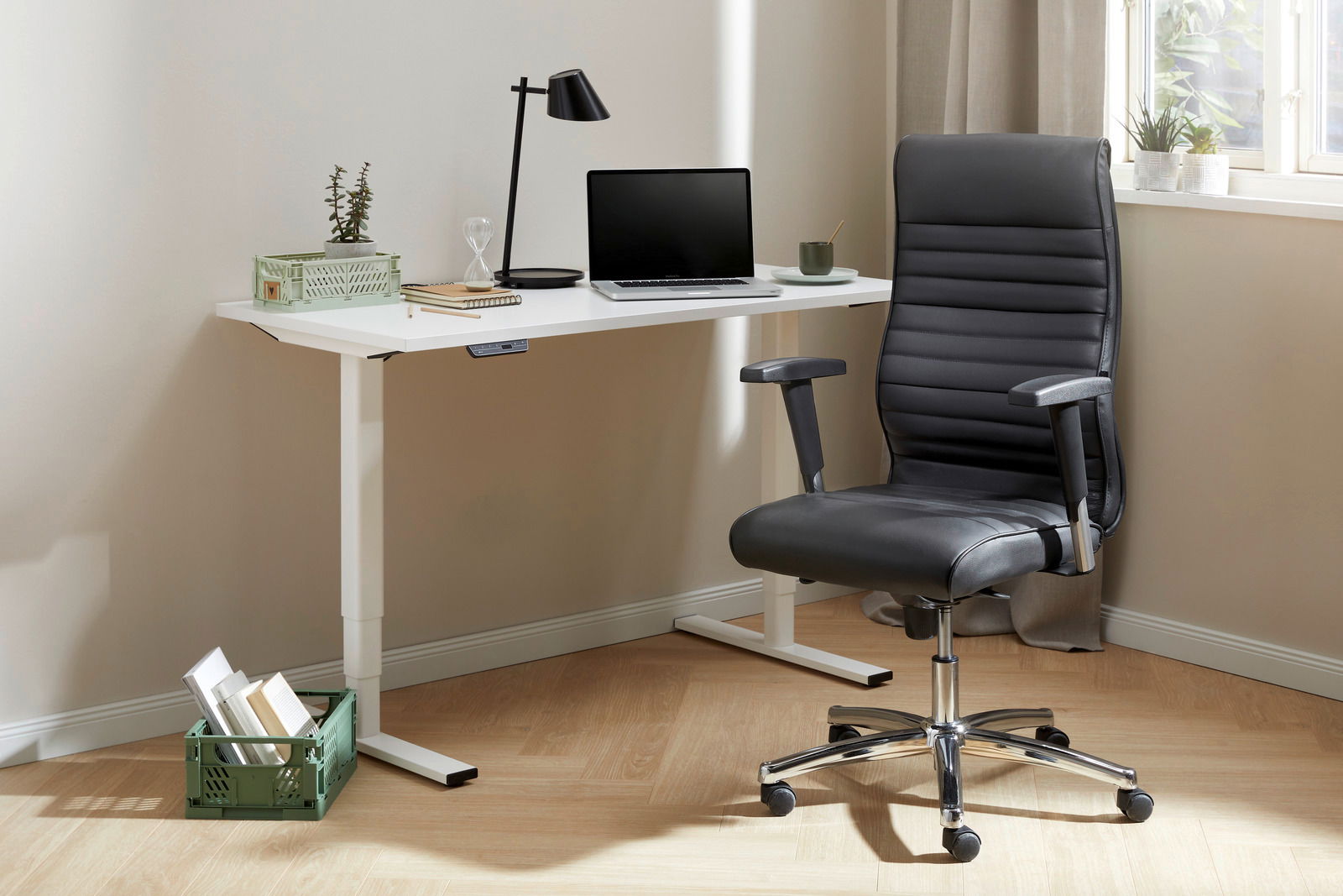 Topstar Chefsessel PROFI CHIEF 100 Moderner Chefsessel in schwarzem Leder, seitliche Perspektive, neben einem weißen Schreibtisch mit Laptop und Lampe.