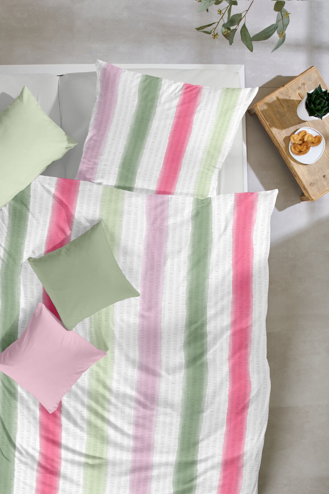 Primera Bettwäsche Bettwäsche-Set mit vertikalen Streifen in Rosa und Grün auf weißem Grund, auf einem Bett mit farblich passenden Kissen, Draufsicht von oben