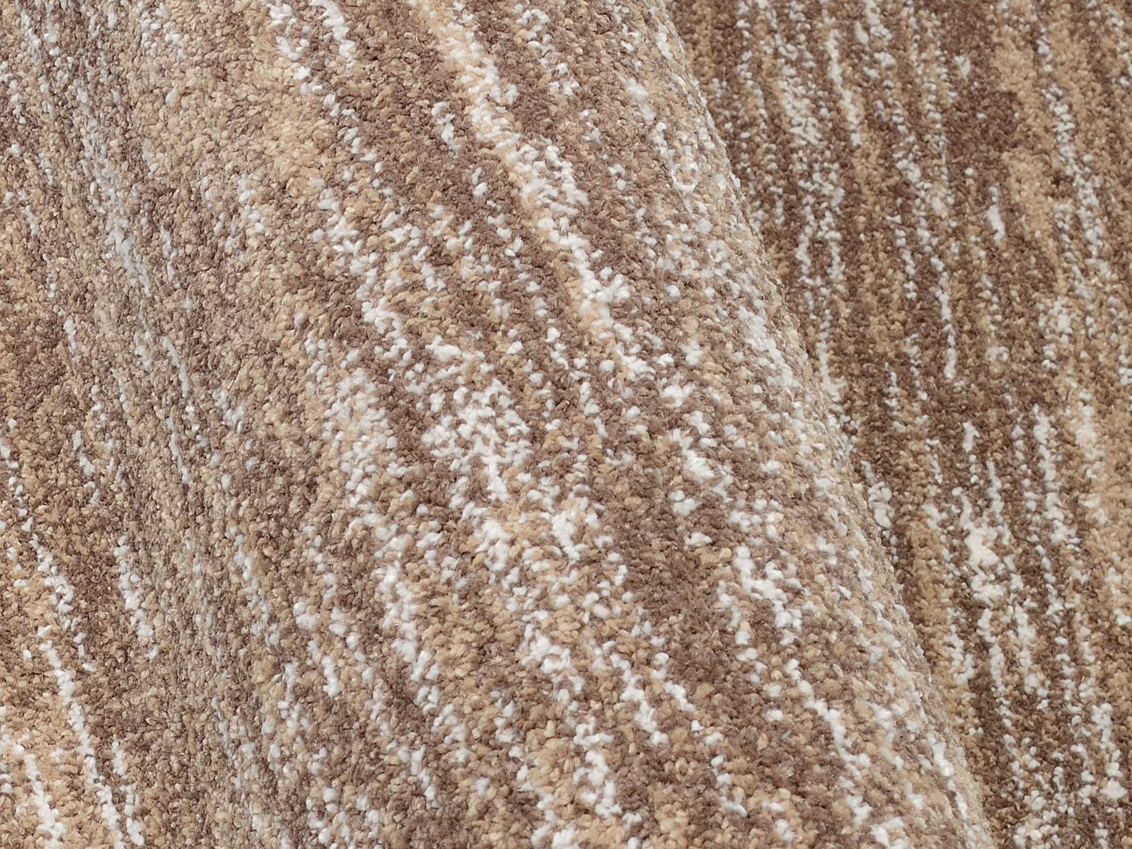 Nahaufnahme eines Uni-Teppichs in verschiedenen Brauntönen mit einer strukturierten Oberfläche.