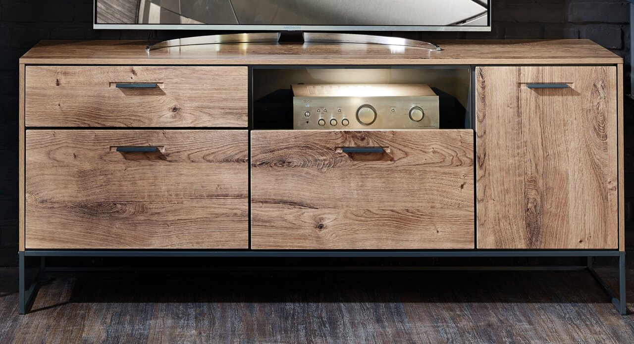 Frontansicht des Zurbrüggen Sideboards MANHATTAN mit Holzoptik, zwei Schubladen, einem offenen Fach und einer Tür.