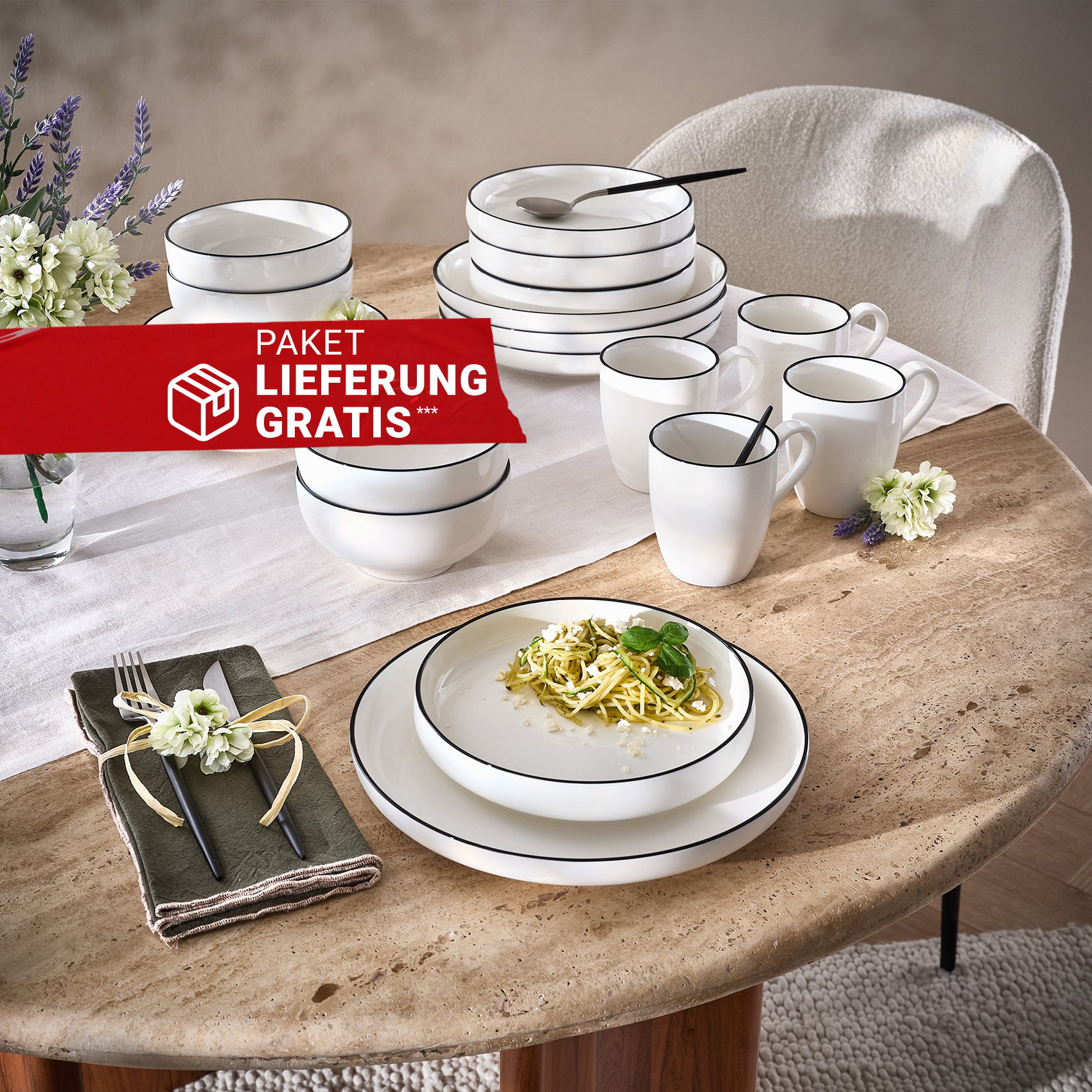 Weißes Geschirr mit schwarzem Rand auf gedecktem Esstisch, dekoriert mit Blumen und Besteck.
