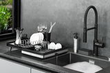 Abtropfgestell SMARTLINE auf einer Küchentheke neben einem Waschbecken, gefüllt mit Geschirr und Besteck, seitliche Perspektive.