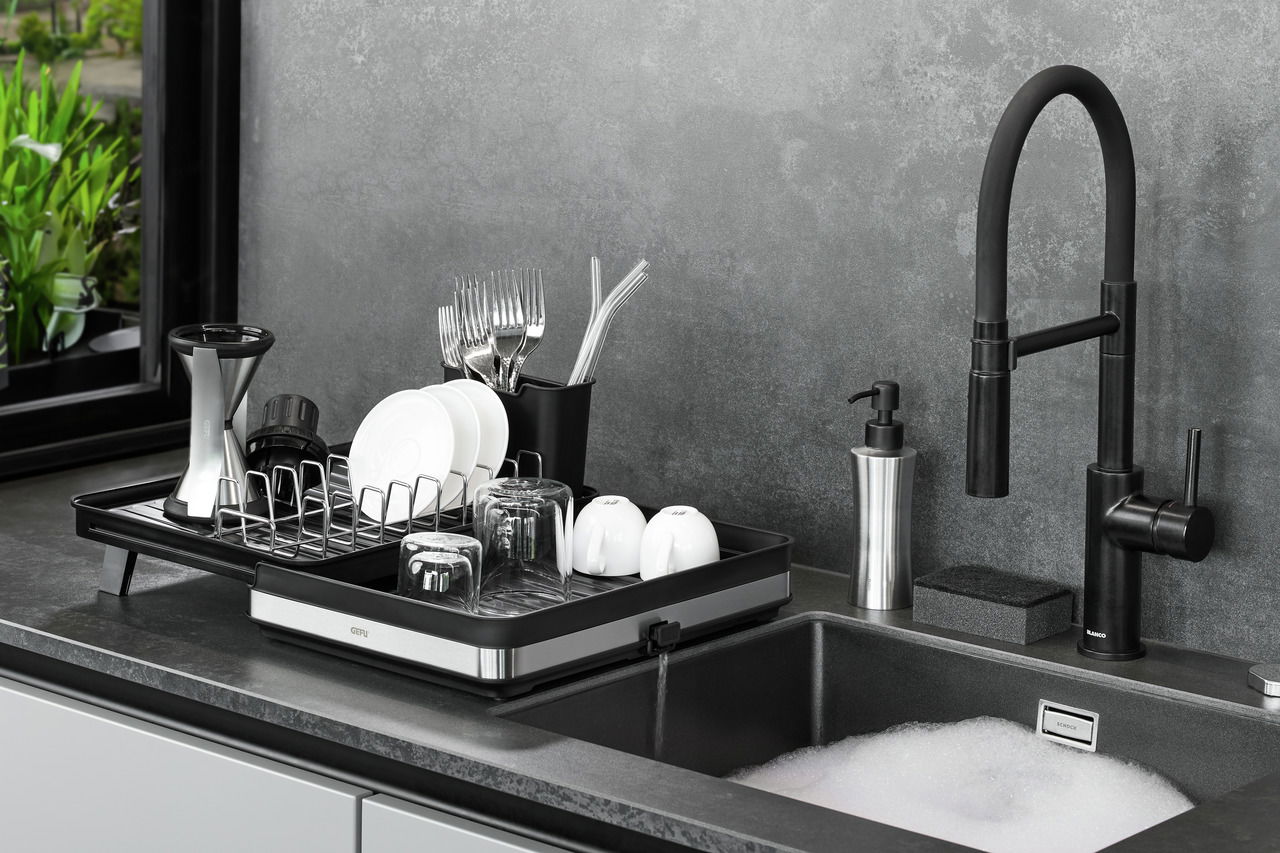 Abtropfgestell SMARTLINE auf einer Küchentheke neben einem Waschbecken, gefüllt mit Geschirr und Besteck, seitliche Perspektive.