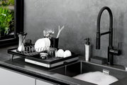 Abtropfgestell SMARTLINE auf einer Küchentheke neben einem Waschbecken, gefüllt mit Geschirr und Besteck, seitliche Perspektive.