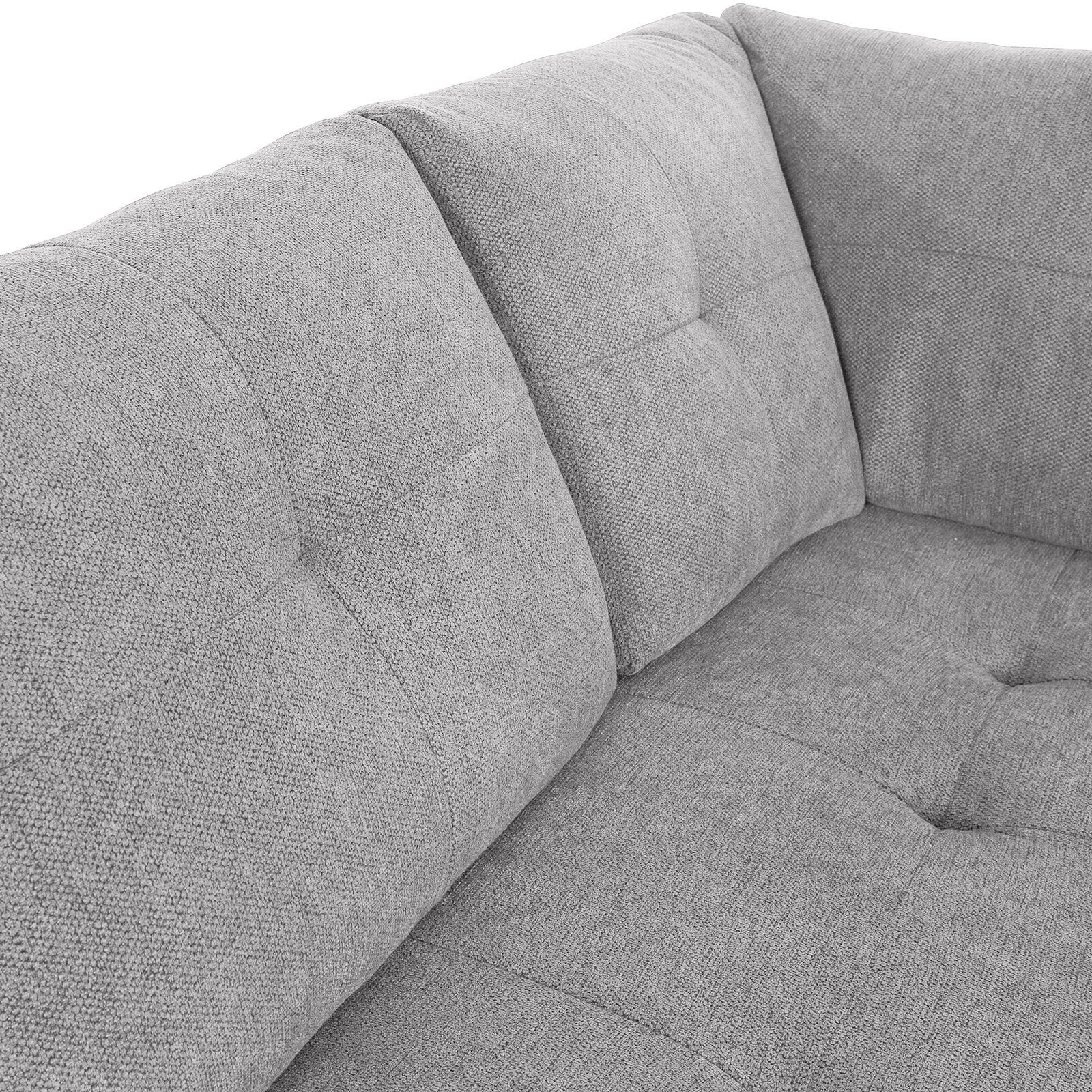 Nahaufnahme einer grauen, gepolsterten Sofaecke mit texturierter Oberfläche und Steppnähten, Perspektive von oben.