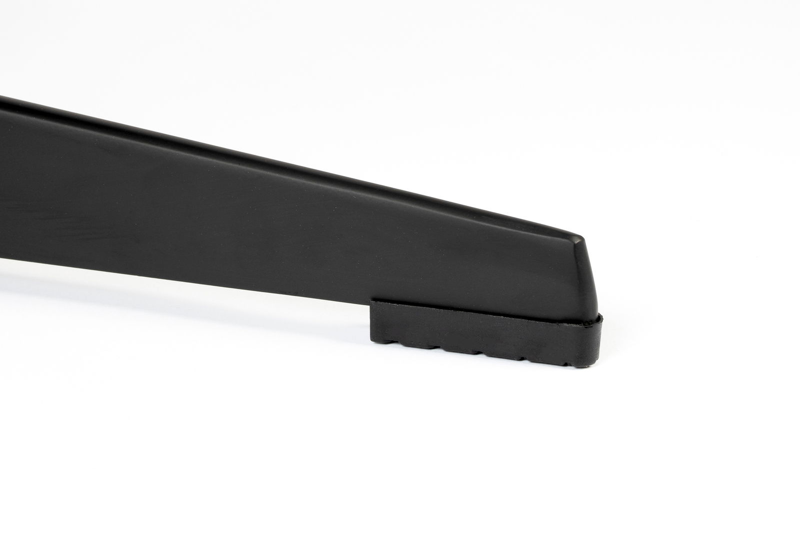 Nahaufnahme eines schwarzen Stuhlbeins mit gummierter Unterseite, seitliche Perspektive