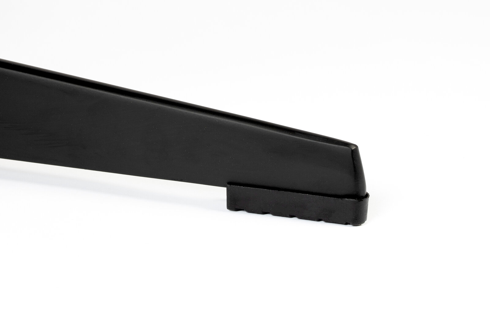 Nahaufnahme eines schwarzen Stuhlbeins mit gummierter Unterseite, seitliche Perspektive