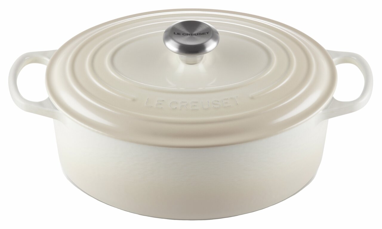 Ovaler cremefarbener Bräter von Le Creuset mit Deckel und seitlichen Griffen, Ansicht von vorne.