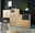 Modernes Sideboard aus Holz mit schwarzen Schubladen, dekoriert mit Pflanzen und einer Lampe, in einer stilvollen Wohnzimmerecke. Perspektive von vorne.