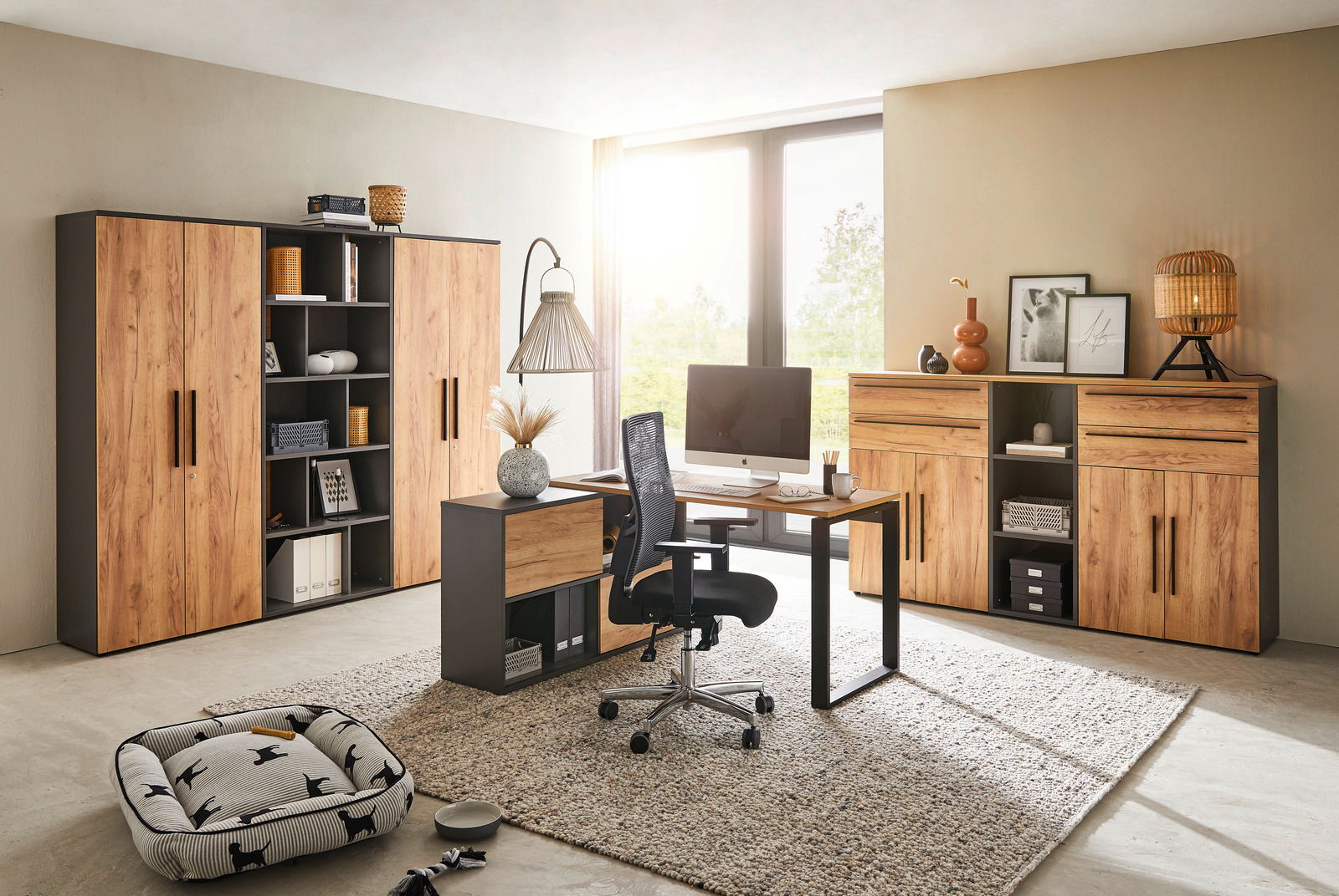 Moderne Büromöbel in einem hellen Raum mit Schreibtisch, Rollcontainer und Aktenschränken in Holzoptik. Perspektive von vorne.