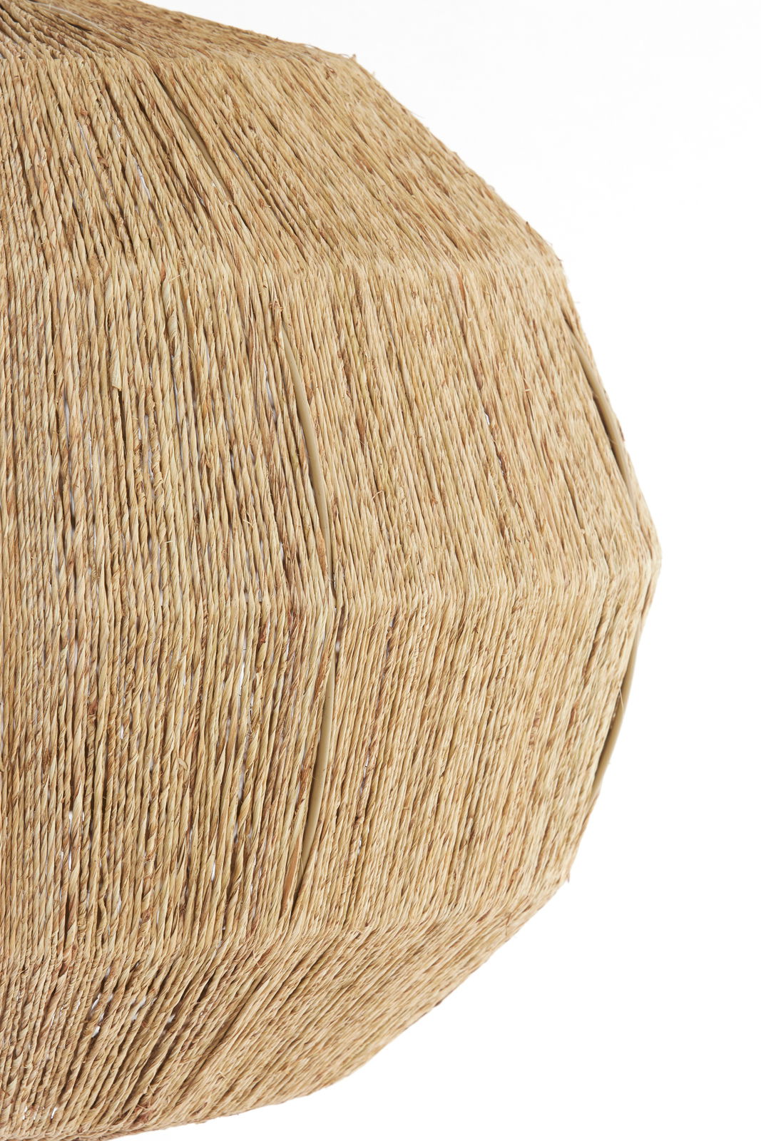 Nahaufnahme einer Hängeleuchte mit natürlicher, geflochtener Struktur aus Stroh oder Bast, seitliche Perspektive.