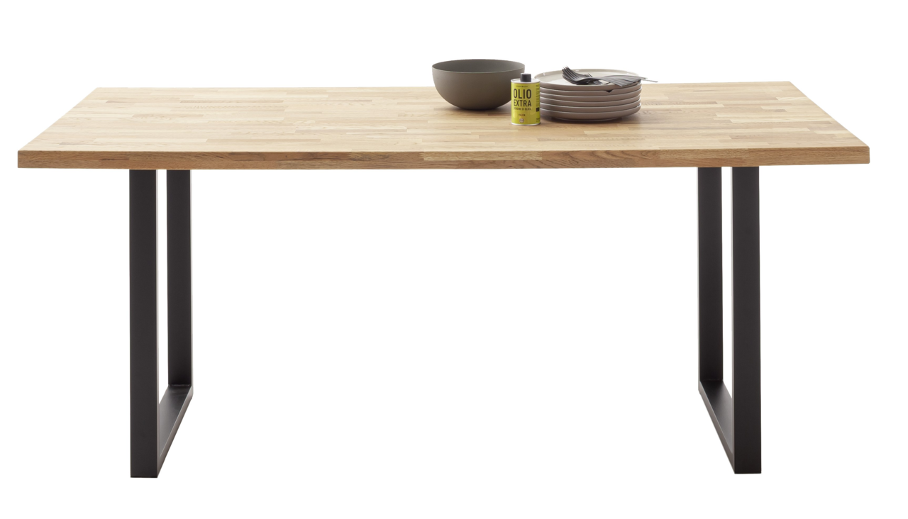 Esstisch aus Holz mit schwarzem Metallgestell, frontal fotografiert, mit Geschirr und Ölflasche als Dekoration.