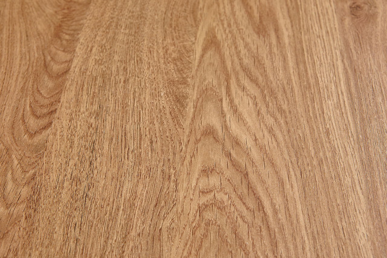 Nahaufnahme einer Holzoberfläche mit natürlicher Maserung, aus der Vogelperspektive aufgenommen.