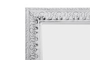 Detailansicht eines weißen, kunstvoll verzierten Spiegelrahmens der Serie EMMA.