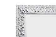 Detailansicht eines weißen, kunstvoll verzierten Spiegelrahmens der Serie EMMA.