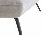 Close-up van een ligstoel met een lichtgrijze, geribbelde stoffen bekleding en zwarte metalen poten, gezien vanaf de zijkant.