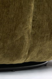 Nahaufnahme eines grünen Sessels mit Stoffbezug, Fokus auf die untere Kante und den schwarzen Sockel.