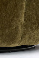 Nahaufnahme eines grünen Sessels mit Stoffbezug, Fokus auf die untere Kante und den schwarzen Sockel.