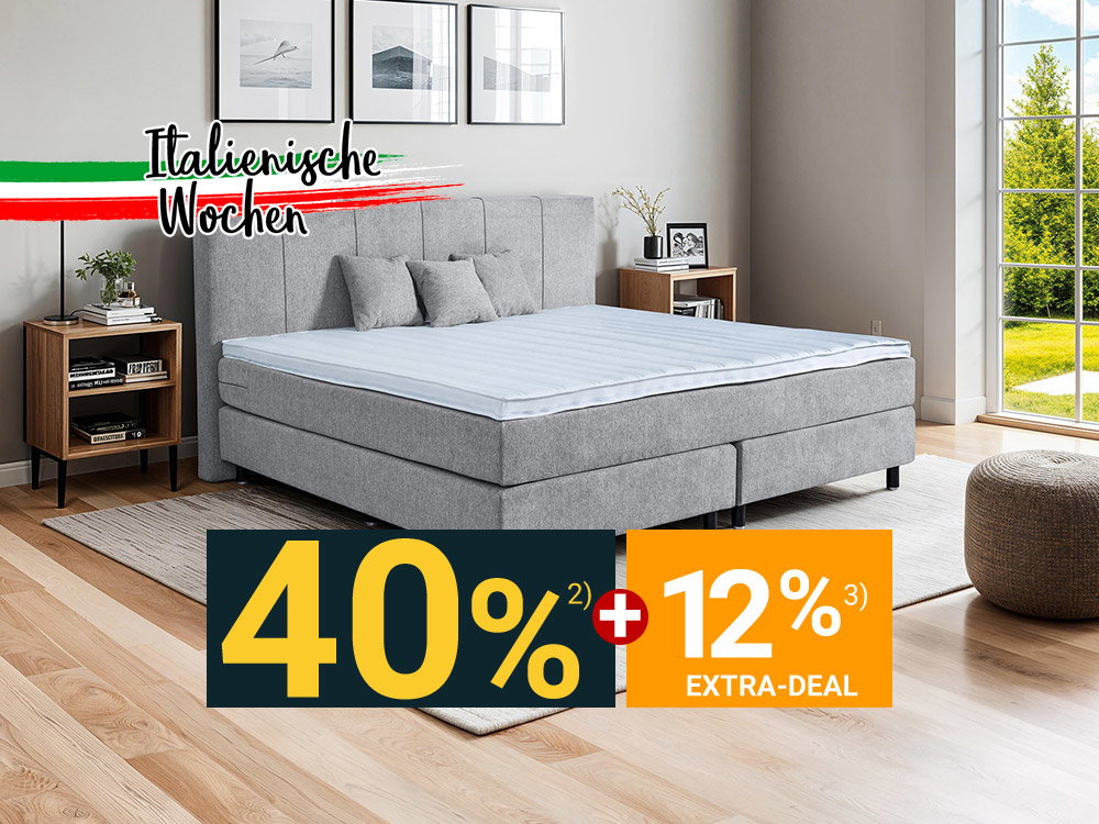 Modernes Boxspringbett in Grau mit Polsterkopfteil im hellen Schlafzimmer mit Fenster und Nachttischen