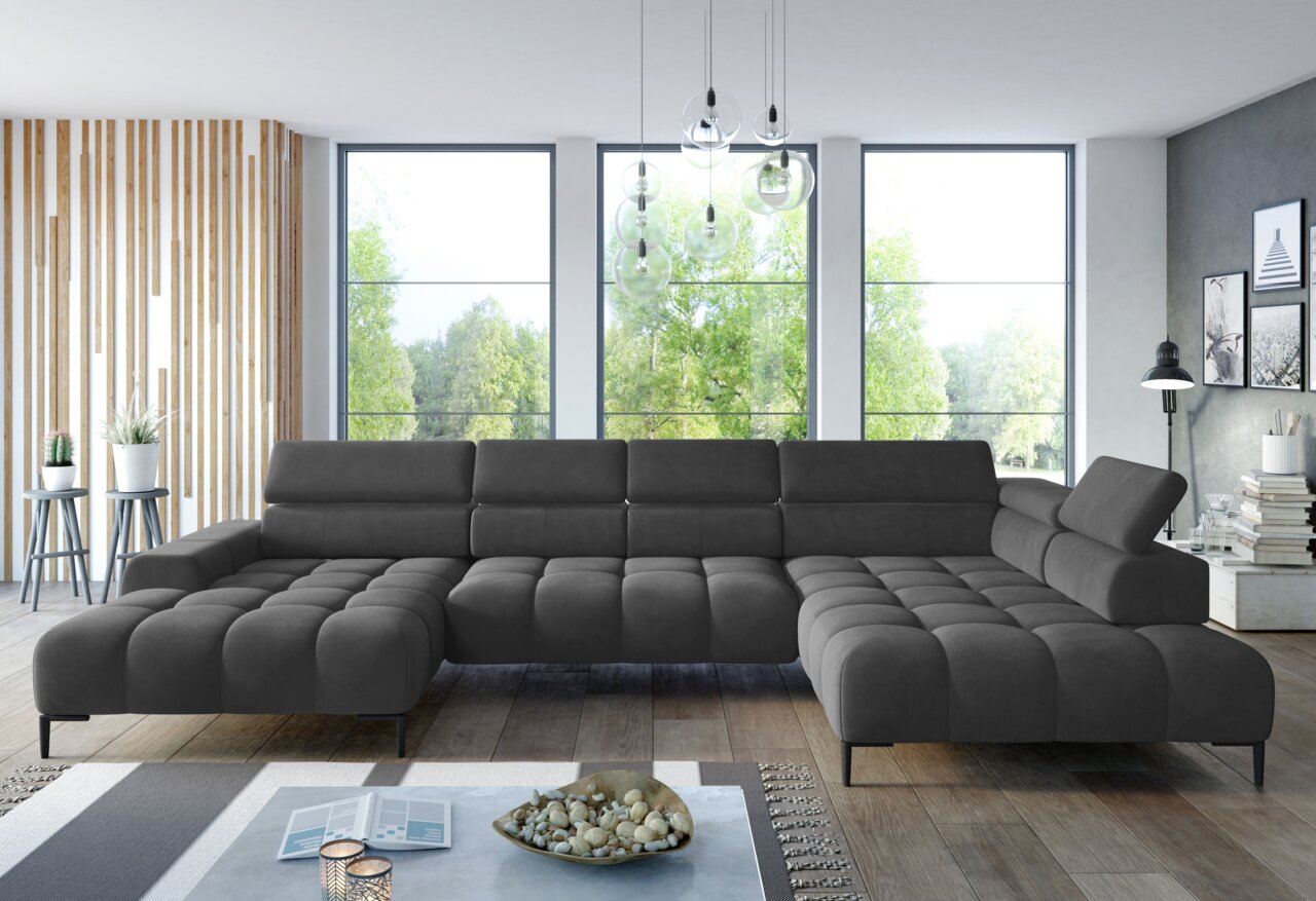 Große, moderne Polsterrundecke in dunklem Grau, in einem stilvollen Wohnzimmer mit großen Fenstern und natürlichem Licht, aus frontaler Perspektive betrachtet.