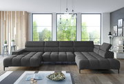 Große, moderne Polsterrundecke in dunklem Grau, in einem stilvollen Wohnzimmer mit großen Fenstern und natürlichem Licht, aus frontaler Perspektive betrachtet.