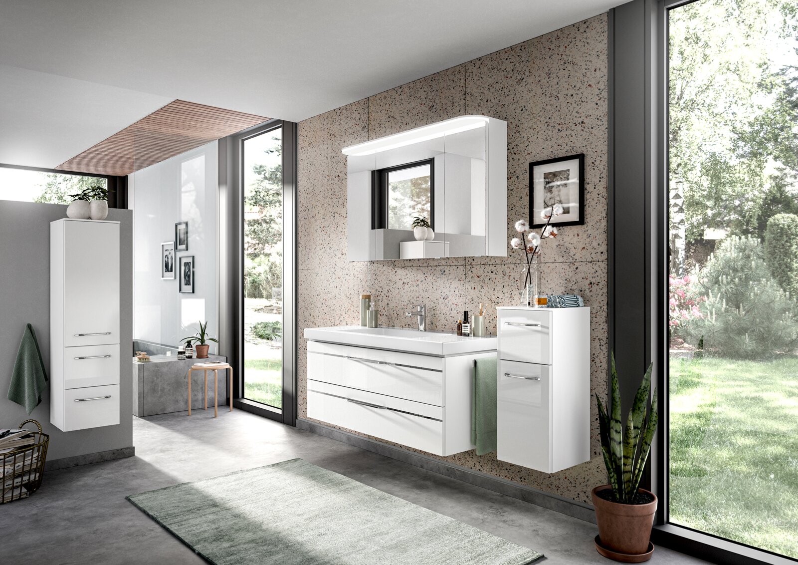 Moderner Badblock in einem hellen Badezimmer mit großen Fenstern, bestehend aus einem weißen Waschtisch mit Schubladen, einem Spiegel mit Beleuchtung und einem hohen Schrank. Perspektive von vorne.