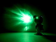 LED-Dekoleuchte in Form eines Astronauten, der mit einem grünen Lichtstrahl an die Wand projiziert. Seitliche Perspektive.
