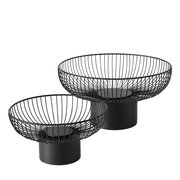 Zwei schwarze, moderne Drahtschalen auf zylindrischen Sockeln, seitliche Perspektive.