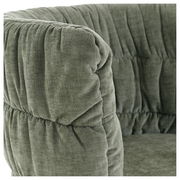 Nahaufnahme eines grünen Armlehnstuhls mit weicher, gepolsterter Oberfläche und gerafftem Stoff.