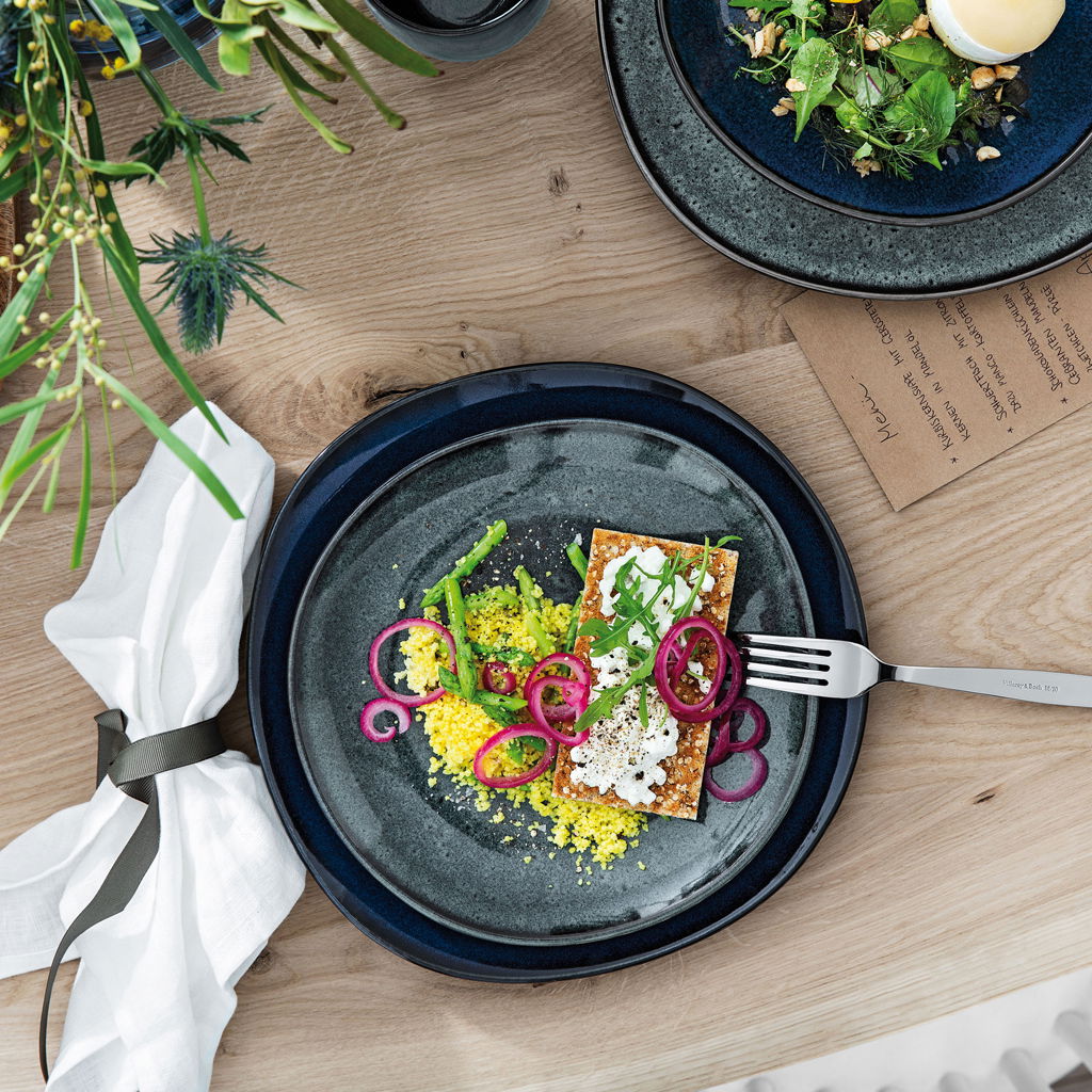 Frühstücksteller Lave 23,5cm grau, von oben fotografiert, mit dekorativ angerichtetem Essen auf einem Holztisch.